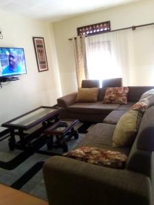 a living room with a couch and a coffee table at Kampala Ntinda Comfy Holiday Home in Kampala