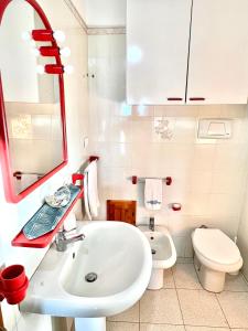 Baño blanco con lavabo y aseo en Casa Giada Costa Rei, en Costa Rei