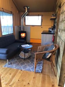 a living room with a couch and a table and a stove at The Paddock in Bredon