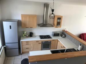 a small kitchen with a refrigerator and a sink at Agréable maison de bourg aux portes de TOURS in Semblançay +8 photos
