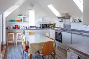 a kitchen with a table and some chairs in it at Coastguard Lookout in Weymouth