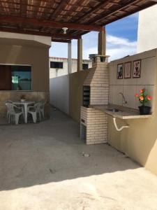 patio z kuchnią, stołem i krzesłami w obiekcie Casa Duplex nas Dunas do Peró w mieście Cabo Frio