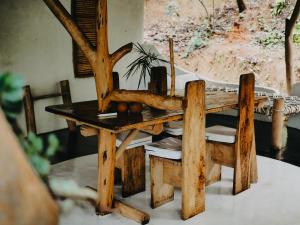 a wooden table with a chair and a table with a tree at Ella Retreat Hotel Villa for Nature Lovers in Ella