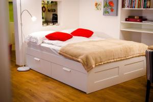 a bed with red pillows on it in a bedroom at Design Loft Rossau in Vienna