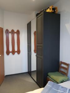 エアフルトにあるFerienwohnung Döringのベッドルーム1室(壁にギター付きの黒いキャビネット付)