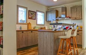 a kitchen with wooden cabinets and a bar with stools at Gorgeous Home In Tourrettes in Tourrettes
