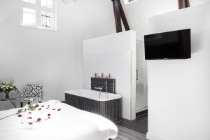 een slaapkamer met een bed, een wastafel en een tv bij Gasterij Posthuys in Leerdam