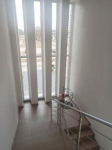 ダウガフピルスにあるLOFT Homeの窓とテーブルのある階段付きの廊下