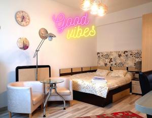 a bedroom with a bed and a table and a sign that reads good vibes at GOOD VIBES in Cismigiu Studio steps from Subway Self Check IN in Bucharest