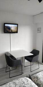 a room with a white table and two chairs at Studio Lou Cigaloun in Gréoux-les-Bains