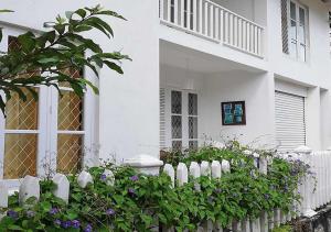 una cerca blanca frente a una casa blanca en White Villa Ambalangoda, en Ambalangoda