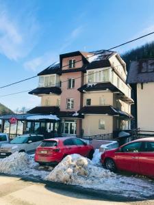 Dos coches estacionados en un estacionamiento frente a un edificio. en Studio-Apartman Dream018, en Brzeće