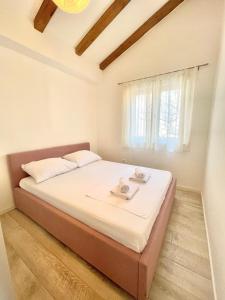 duże łóżko w pokoju z oknem w obiekcie Apartments Maja w mieście Betina