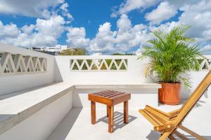 a bench and a chair on a balcony at Casa Yako in Playa del Carmen