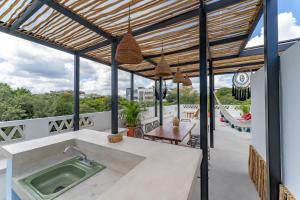 an outdoor kitchen with a hot tub on a balcony at Casa Yako in Playa del Carmen