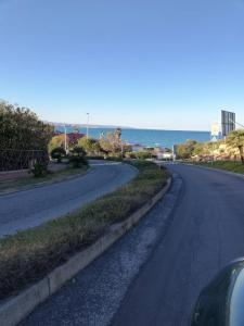 een lege weg met de oceaan op de achtergrond bij Residenza Anna Maria in Crotone