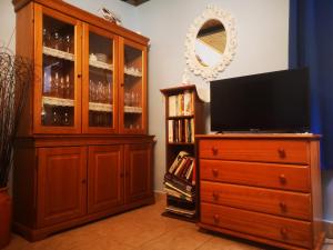 a large wooden cabinet with a television and a dresser at Olaskoaga Goikoa in Aia
