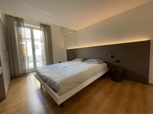 a bedroom with a large bed and a large window at Lovely Loft Molo in Menaggio