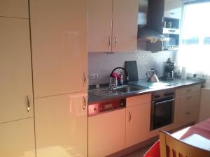 Una cocina con gabinetes blancos y un fregadero. en Europaplatz, en Aachen