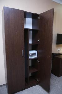 a closet with a door open with a microwave at Hotel Aner in Astana