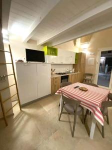 une cuisine avec une table et une cuisine avec une table et des chaises dans l'établissement La maison del corso, à San Foca