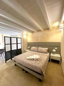 une chambre avec un grand lit avec deux oreillers dessus dans l'établissement La maison del corso, à San Foca