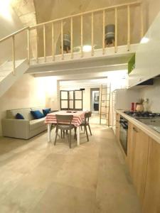 - une cuisine avec une table et un canapé dans une chambre dans l'établissement La maison del corso, à San Foca