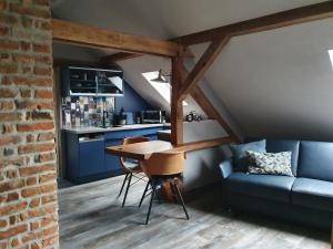 eine Küche mit einem Tisch und einem blauen Sofa in der Unterkunft Aparthotel-Stadtallendorf in Stadtallendorf
