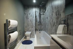 a bathroom with a tub and a toilet and a sink at Penrhiw Farm B & B in Goodwick