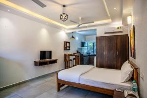 a bedroom with a bed and a tv at Whiteboard Homes Siolim in Siolim