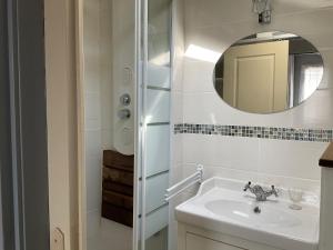une salle de bain avec un lavabo et un miroir dans l'établissement Location maison de vacances à Sainte-Marie-Plage, à Sainte-Marie-la-Mer 28 autres photos