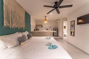 a bedroom with a large white bed with a ceiling fan at Casa Yako in Playa del Carmen +131 photos