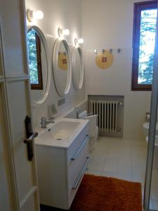 ein weißes Badezimmer mit einem Waschbecken und 2 Spiegeln in der Unterkunft Casale La Pineta in Mombaroccio