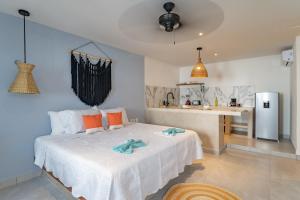a bedroom with a large bed and a kitchen at Casa Yako in Playa del Carmen