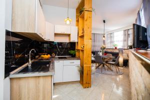 a kitchen with white cabinets and a dining room at Glicinia in Šibenik
