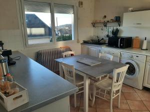 a kitchen with a table and chairs in a kitchen at Maison chaleureuse avec cheminée et extérieur in Luxeuil-les-Bains
