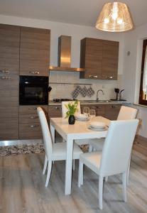 uma cozinha com uma mesa de jantar branca e cadeiras em Albachiara em Castiglione del Lago