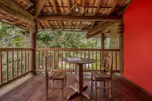 a porch with a table and chairs on a deck at Solar Pitanga - Taipu de Fora in Barra Grande