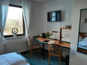 卡塞爾的住宿－Hotel & Restaurant Eichholz，一间卧室配有一张桌子、一张床、一张床、一张桌子和椅子
