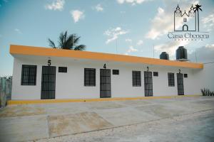 een wit gebouw met zwarte ramen bij Casa Chenera in Campeche