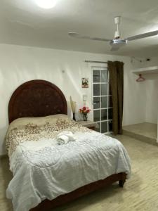 Schlafzimmer mit einem großen Bett mit einem Kopfteil aus Holz in der Unterkunft Casa Liz in Cozumel