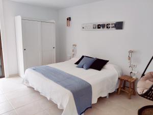 biała sypialnia z dużym łóżkiem i krzesłem w obiekcie MARAVILLA Suite 140 m2 - 3 Bedrooms, Heated Pool w mieście Costa Del Silencio