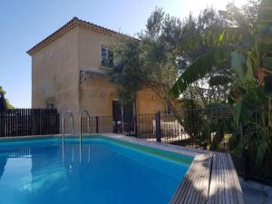 a swimming pool in front of a house at Villa Namasté in Méjannes-lès-Alès