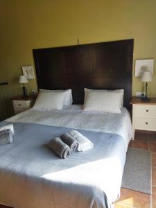 ein großes Bett mit zwei Kissen darüber in der Unterkunft Casa el Sereno in Salas Bajas