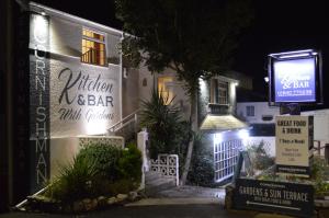 a building with a sign for a restaurant at night at The Cornishman Inn in Tintagel