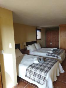 2 Betten in einem Hotelzimmer mit 2 Schlafzimmern in der Unterkunft Casa el Sereno in Salas Bajas