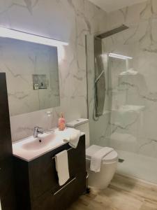 a bathroom with a sink and a toilet and a shower at EL AGAVE DE MERESE APARTAMENTO in Las Toscas +32 photos