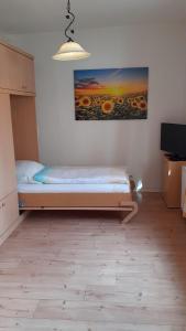 a bedroom with a bed and a painting on the wall at 1-Zimmer-Apartment-2-Hochparterre in Lübeck