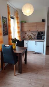 eine Küche mit einem Holztisch und Stühlen sowie einem Tisch und einer Küche in der Unterkunft 1-Zimmer-Apartment 2 Hochparterre in Lübeck