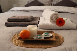 a tray with towels and a candle on a bed at Apartament Południowy in Ruda Śląska